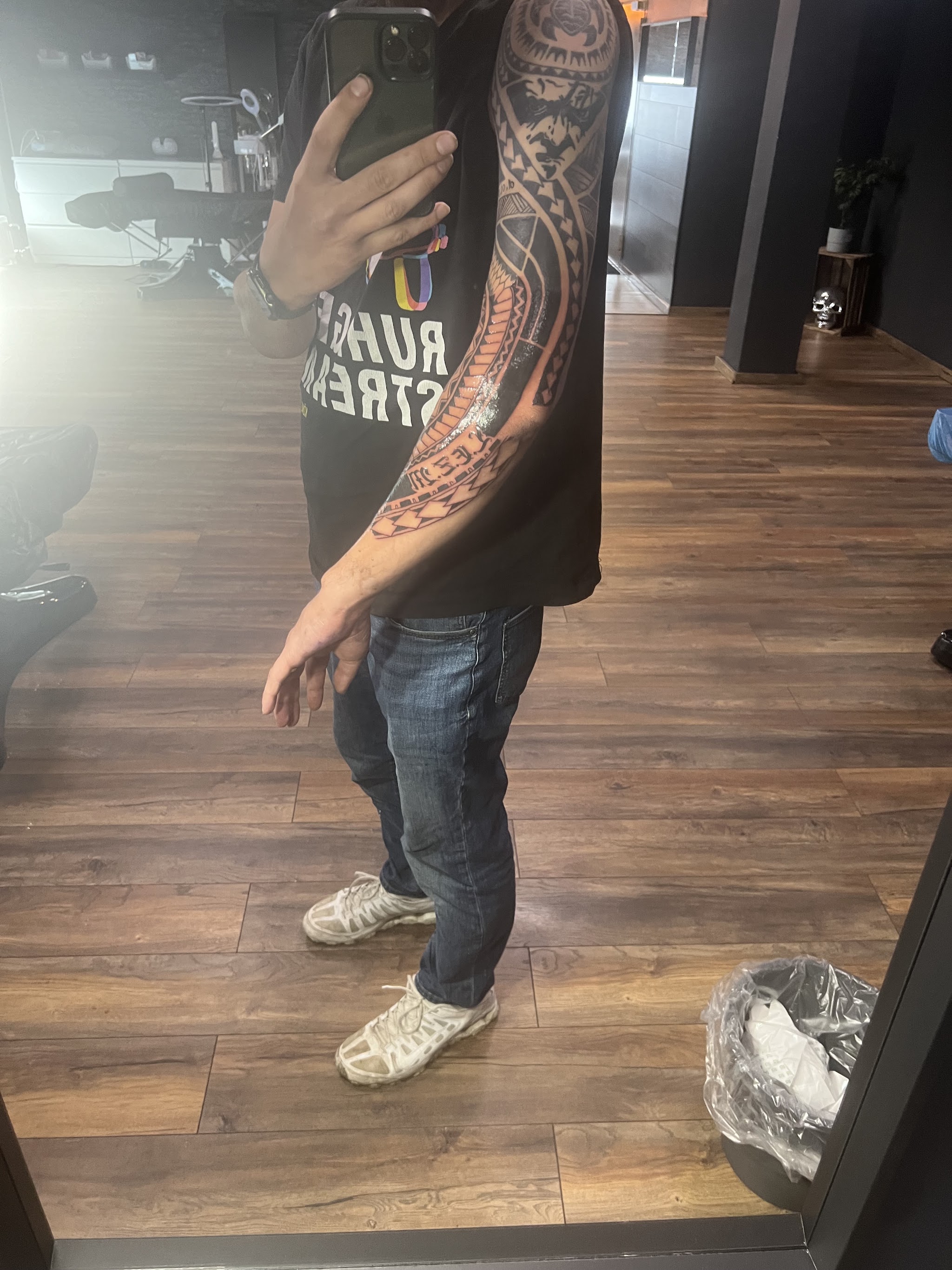 Fertiges Tribal-Sleeve, im Hintergrund das Studio mit Tattooliege