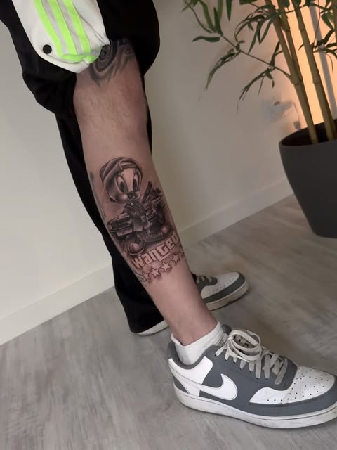 Farbiges Tweety-Tattoo mit Schriftzug Wanted am Unterschenkel
